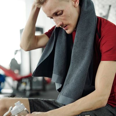 A water bottle and a small towel resting on a training mat.